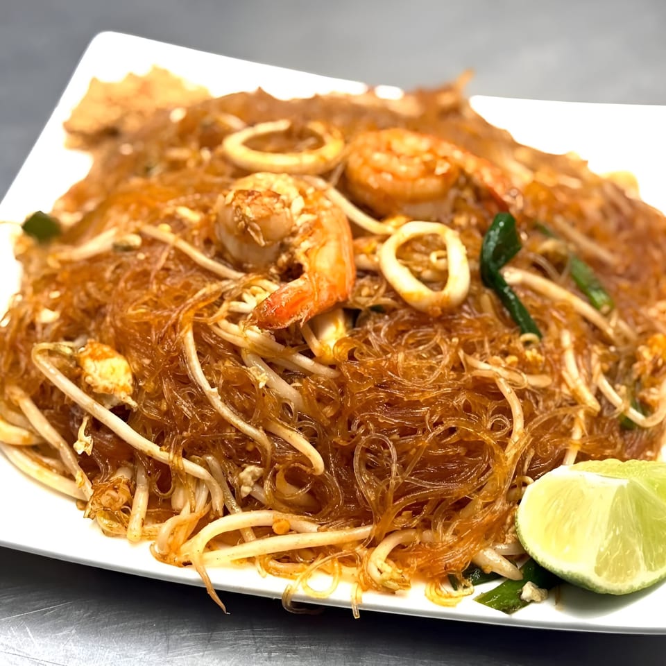 Omaha Mercy Thai's Pad Woon Sen with shrimp, squid, bean sprouts, and a lime wedge.
